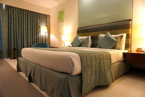 Een blik op een tweepersoonsbed in een hotelkamer